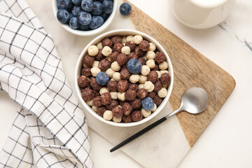Composition with bowls of chocolate corn balls and berries on marble background, closeup