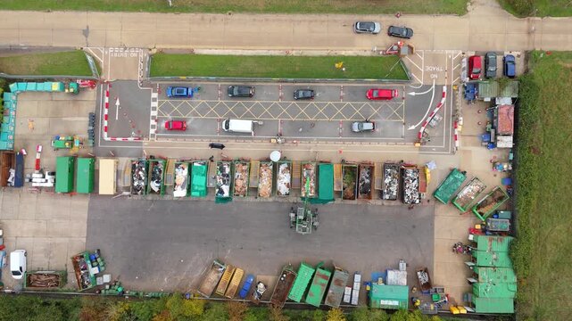 Aerial drone hyperlapse of a domestic waste recycling centre near Canvey Island UK, showing garbage and rubbish being deposited in large skips during daytim