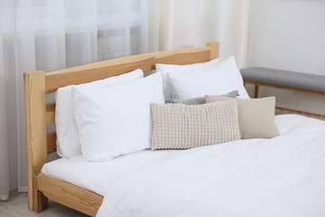 Bed with fresh white linens indoors, closeup