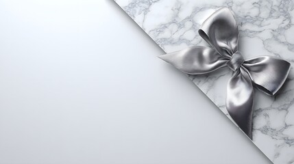 A luxurious silver ribbon bow rests on a split background of textured marble and smooth white.