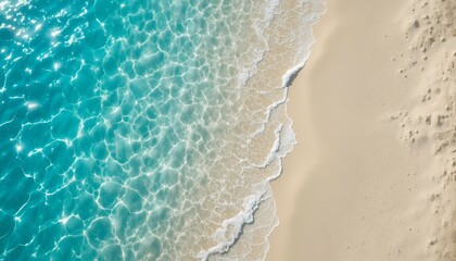 aerial view of turquoise ocean waves gently washing onto soft sandy beach under bright sunlight