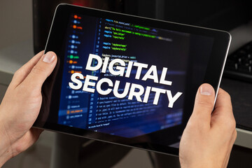 a male hands holding a tablet with the phrase digital security over a writing code concept