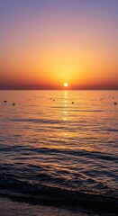 Obraz premium Sunset casts golden light on gentle ocean waves with birds flying.