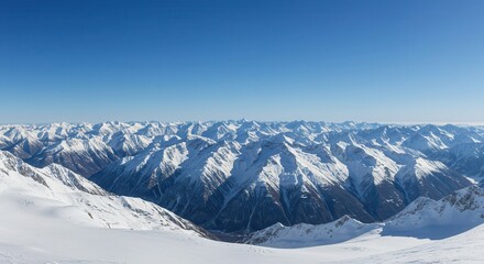 Naklejka premium Vast mountain range covered in snow under a clear blue sky.