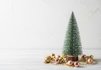 Christmas tree with ornaments on a white wooden table, festive holiday decor