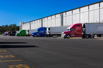 Logistics warehouse exterior with loading bays and trucks.
