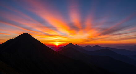 Dramatic sunrise over mountain range, with vibrant colors painting the sky and creating a stunning and aweinspiring natural spectacle