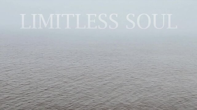 A long, fixed shot video of a tranquil sea beneath a mist-covered sky, and at the top of the frame, the text &ldquo;Limitless Soul&rdquo; appears