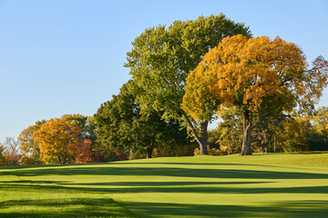 A beautifully manicured fairway with trees turning vivid colors in fall near Minneapolis Minnesota USA