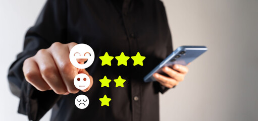 A person holds a cell phone while pointing forward to a customer satisfaction review