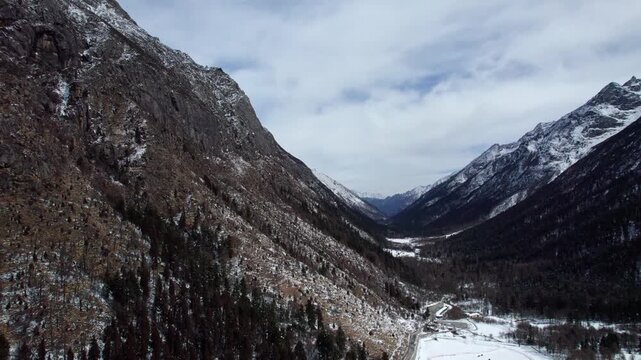 Drone view of snow covered mountains and forests in Bipeng Valley in Sichuan, China in sunny winter day, high angle view of beautiful winter landscape. 4k real time footage, travel concept.