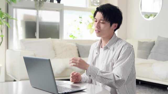 パソコン作業で肩が痛くなるアジア人男性