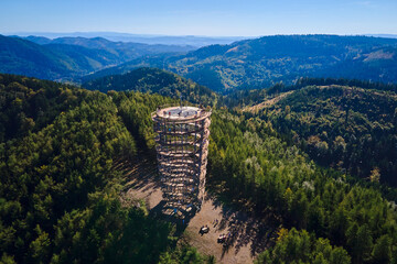 Aerial view of Dzikowiec Wielki observation tower surrounded by green forest and mountains with...