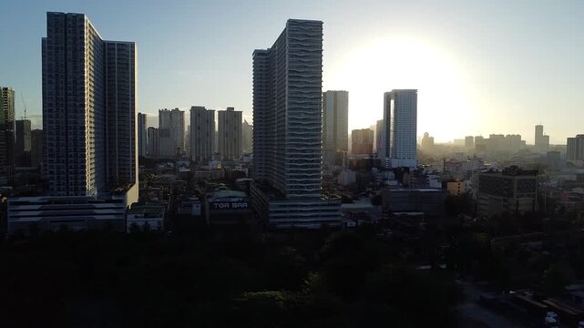 4K Drone Footage Over Pasay City Metro Manila, Philippines &mdash; Sunrise View of Urban Buildings, City Skyline, and Morning Light Over Modern Architecture and Streets