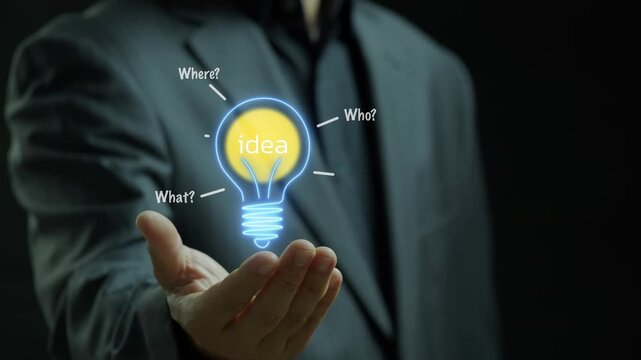 Businessman shows animated neon lightbulb with the word "Idea" inside on virtual screen. Represents business concepts, innovation, brainstorming, creative thinking and new solutions.