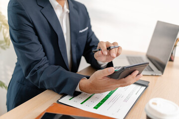A businessman in a suit analyzing financial charts and performance reports in a bright modern office, focusing on strategy, data, and budget planning for company growth and long-term success.