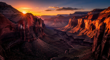 Sunburst illuminates the majestic canyon walls at sunset, casting a warm glow over the rugged landscape