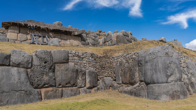 The ancient archaeological complex  Sacsayhuaman. Ruins of a Magnificent Inca Fortress. Walls with polygonal ashlar masonry, terraces baluartes. Blue sky, clouds. Peru. Cusco