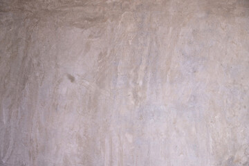 Distressed gray concrete wall texture with exposed aggregate and mottled finish.
