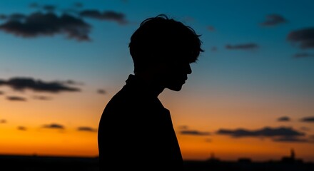 Silhouette of a young person against a vibrant sunset sky.