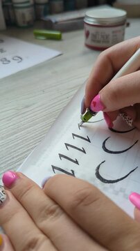 Creative lettering art with ink pen on paper. Artist perfecting decorative handwriting, showing focus, patience, and dedication to artistic mastery. Artistic calligraphy in progress.