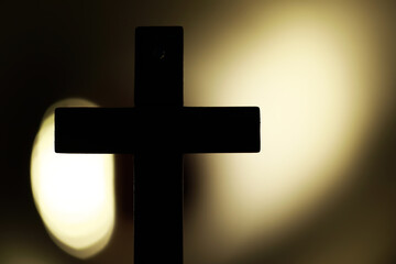Naklejka premium Silhouette of a Cross Against Dramatic Backlit Glow Capturing Spiritual Serenity