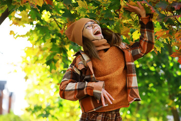 Joyful Girl Enjoying Autumn Outdoors in Warm Cozy Clothing