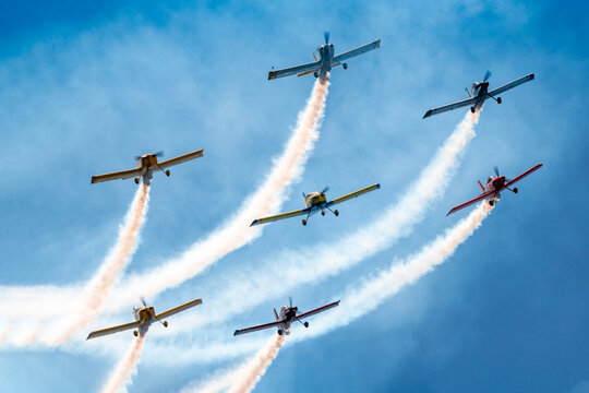 Acrobat planes fly in formation with smoke trailing behind them
 - Powered by Adobe