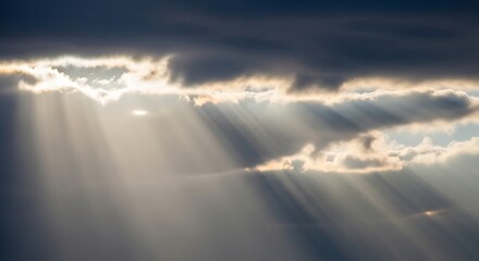 Fototapeta premium Sunlight rays breaking through dark storm clouds in sky