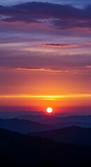 Obraz premium Vibrant Sunset Over Mountain Range with Colorful Sky.