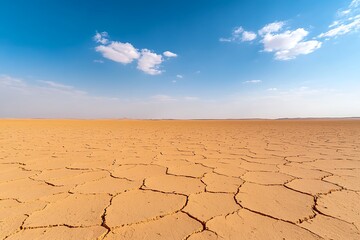 Expansive Desert Landscape with Cracked Earth Under Bright Blue Sky and Fluffy White Clouds