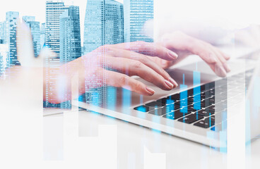 Hands typing on a laptop keyboard with overlaid skyscrapers and bar charts, on a white background. Concept of modern business, finance, and technology