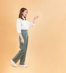 Cheerful Asian businesswoman hand touching or pointing upward with her hand, isolated against a...