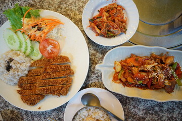 Close up assorted Korean Food- Stir fry pork served with Kimchi(Fermented vegetables), curry soup and steamed white rice