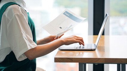 Restaurant clerk entering data on a laptop