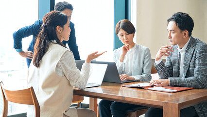 オフィスで会議するカジュアルなビジネスパーソンのグループ