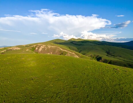 Sunlit rolling green hills under a clear blue sky