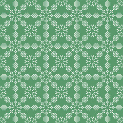 Snowflakes seamless pattern on green background.Festive illumination for textile, wrapping paper and packaging. Holiday backdrop.