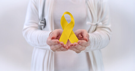 Doctors Hands Presenting Yellow Awareness Ribbon - Awareness Concept