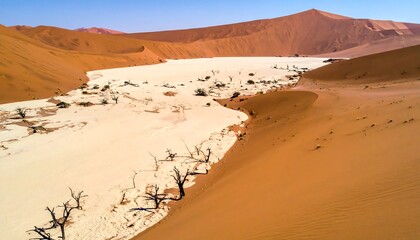 Aerial view of desert, valley, and a mountain range under a clear sky