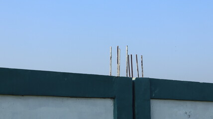 Reinforced concrete protrudes from a concrete fence