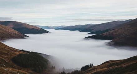 Obraz premium quotes on the mountains - A serene valley surrounded by rolling hills, shrouded in mist, creating a dreamlike atmosphere with soft clouds drifting above a tranquil landscape