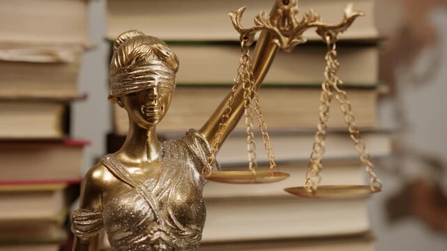Fair legislation, statue of justice on background of stacks of books with laws and rights
