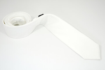 A white tie rolled on white background close-up view 