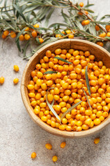 Sea buckthorn berries filling wooden bowl on table