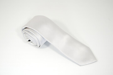 Polyester fabric necktie rolled on white background close-up view 