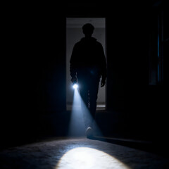 silhouette of a man in the dark with flashlight