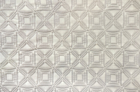 Close up of random modern geometrical diamond shape pattern in white, and grey color. Suitable for carpet, rug, wallpaper, and fabric upholstery. Seamless background texture.