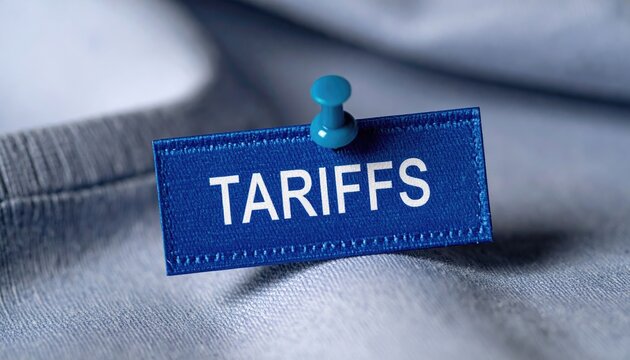 Blue Fabric Tag with White Text TARRIFS Pinned to Light Blue Fabric with Blue Pushpin Macro Shot