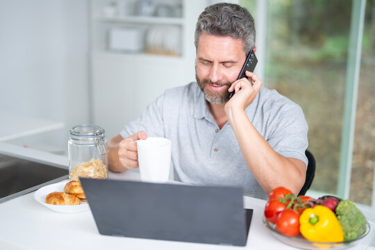 Mature man eating morning breakfast. Healthy food in kitchen for aged mature man. Portrait of senior man at kitchen and eat lunch. 50s man eating breakfast in cozy kitchen at home.